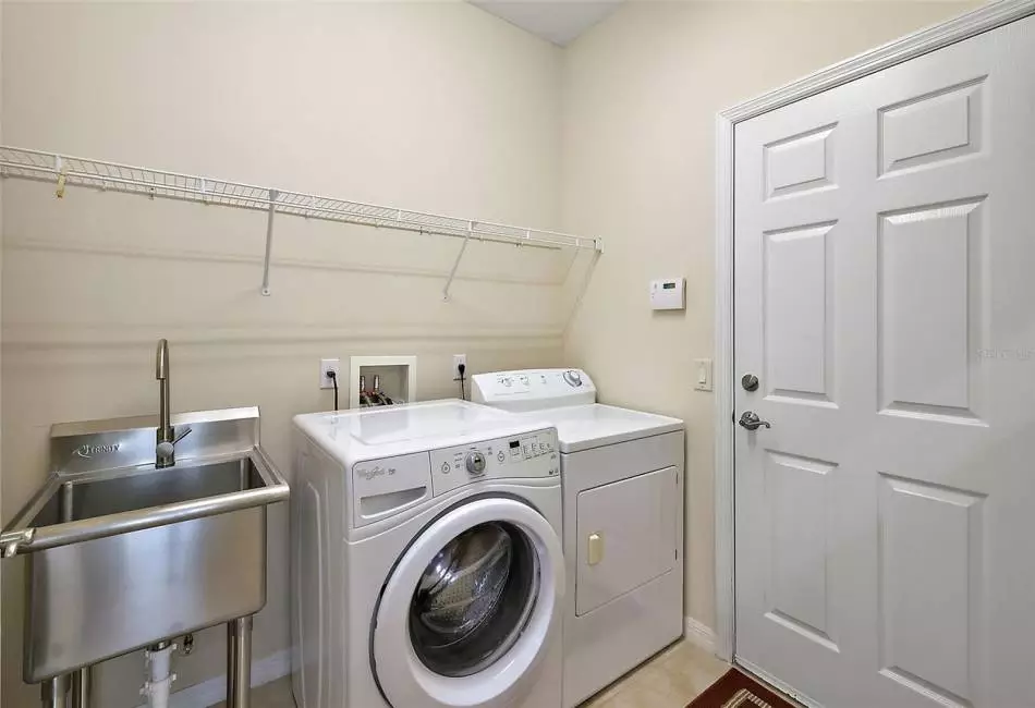 Expanded Utility Room with Stainless TUB, Front load Washer and Gas Dryer. The door goes out to the 2 car Garage.