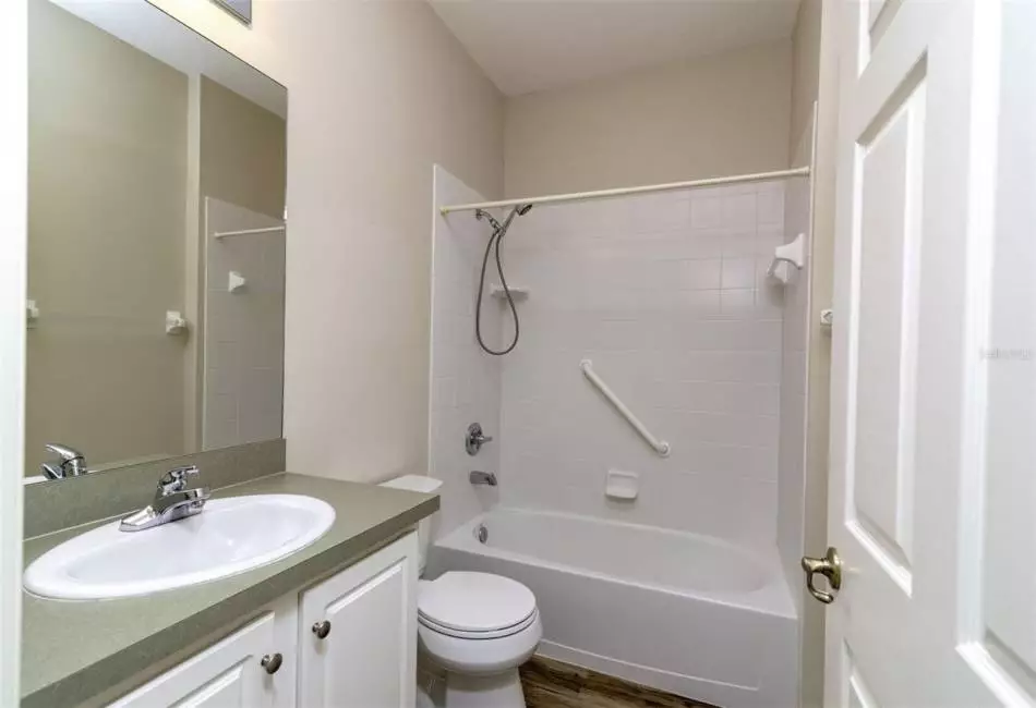 Guest bathroom with tile surround tub and shower