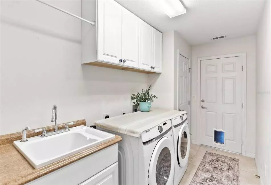 Inside Laundry Room with custom cabinets and utility sink