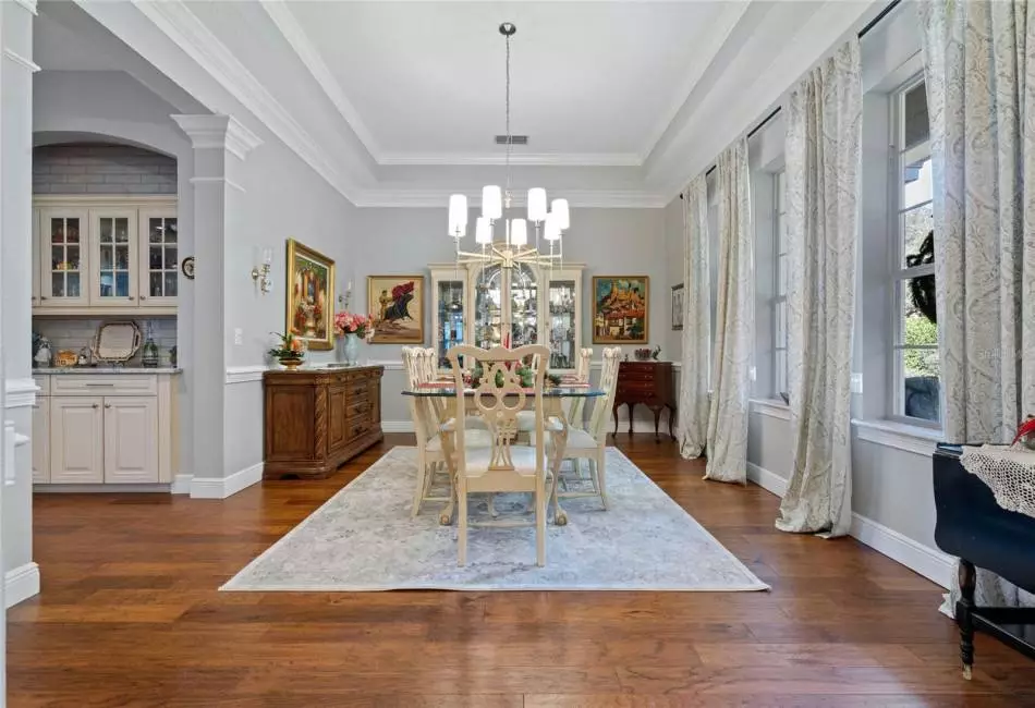 Elongated tray ceilings with crown molding set the mood for family gatherings. Dry bar adds functionality.