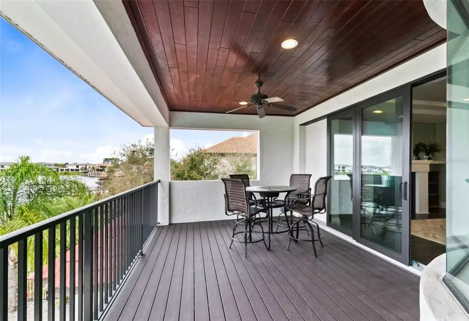 Sliders lead to an expansive balcony with stunning pool and lake views.