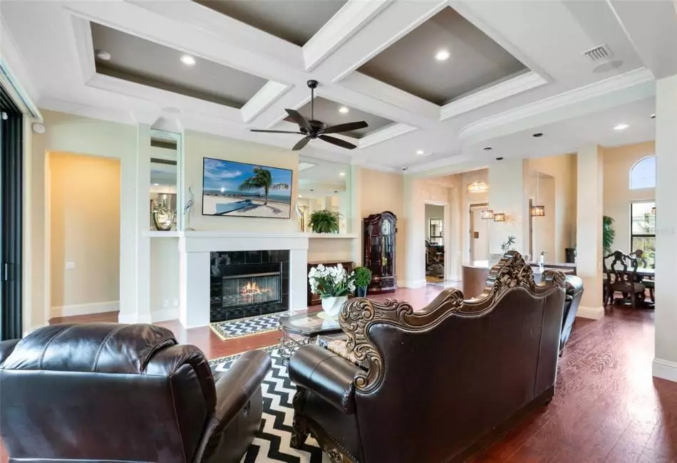 A gas fireplace and coffered ceiling provide a lovely ambiance to the living room.