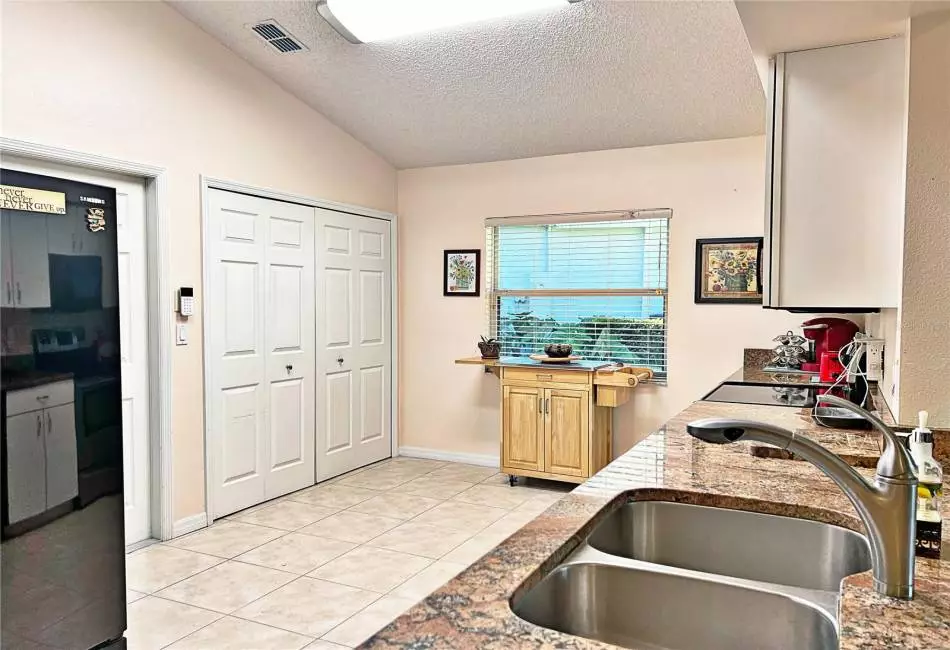 View of Kitchen from Bar top seating, granite countertops, ceramic tile flooring