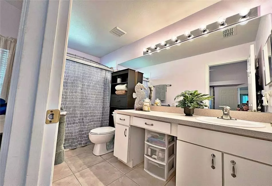 Master bathroom with shower with glass doors, vanity sitting, ceramic tile flooring