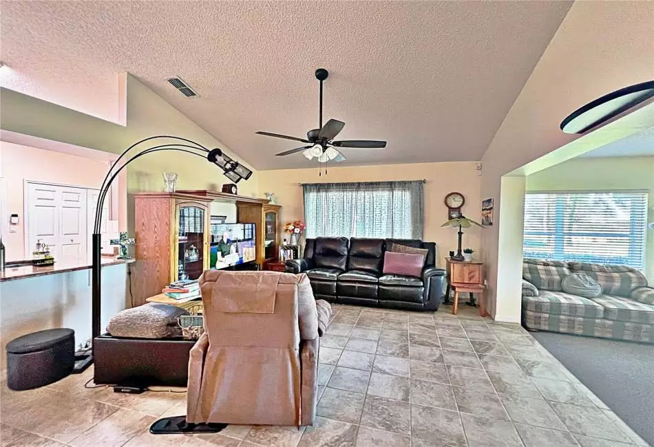 View from. Aster of Living Room, enclosed lanai, and Kitchen bar top seating, ceramic tile flooring in Living Room