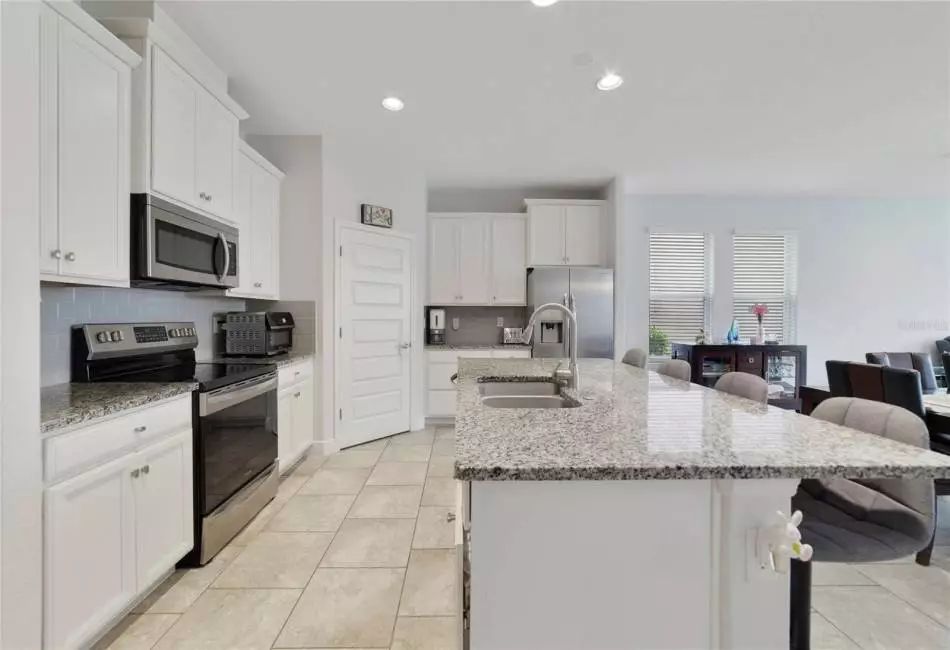 The home chef will appreciate the fresh modern look of the kitchen boasting plenty of cabinet storage plus a WALK-IN PANTRY, stainless steel appliances, granite counters, subway tile backsplash and a large ISLAND with breakfast bar seating for casual dining or entertaining.