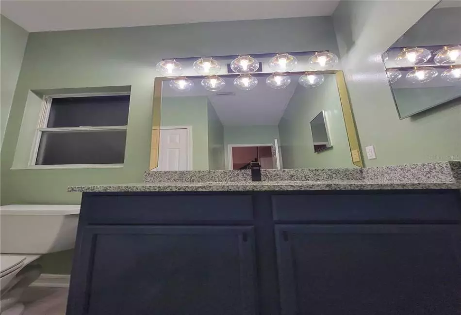 1st Floor half bathroom with Designer Fixtures, Upgraded Lighting and Granite Counters.