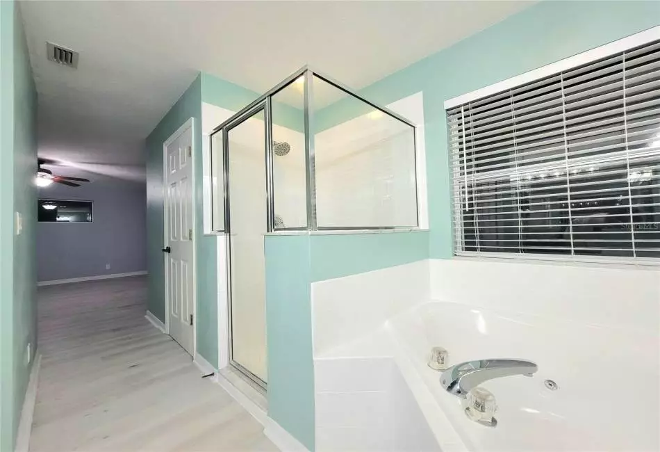 Ensuite Master Bathroom with Upgraded Designer Fixtures and Lighting, Luxury LVP Floors, and an oversized garden soaking and jacuzzi tub, walk-in shower, separate vanities with dual sinks & make-up station, separate enclosed lavatory, and a huge walk-in closet.