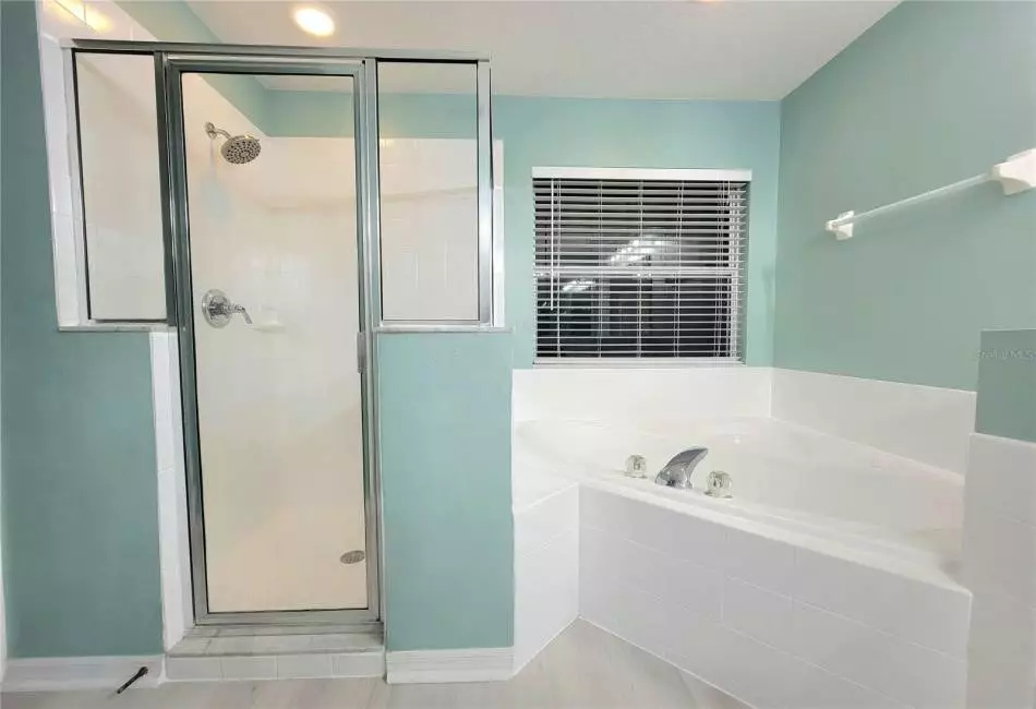 Ensuite Master Bathroom with Upgraded Designer Fixtures and Lighting, Luxury LVP Floors, and an oversized garden soaking and jacuzzi tub, walk-in shower, separate vanities with dual sinks & make-up station, separate enclosed lavatory, and a huge walk-in closet.