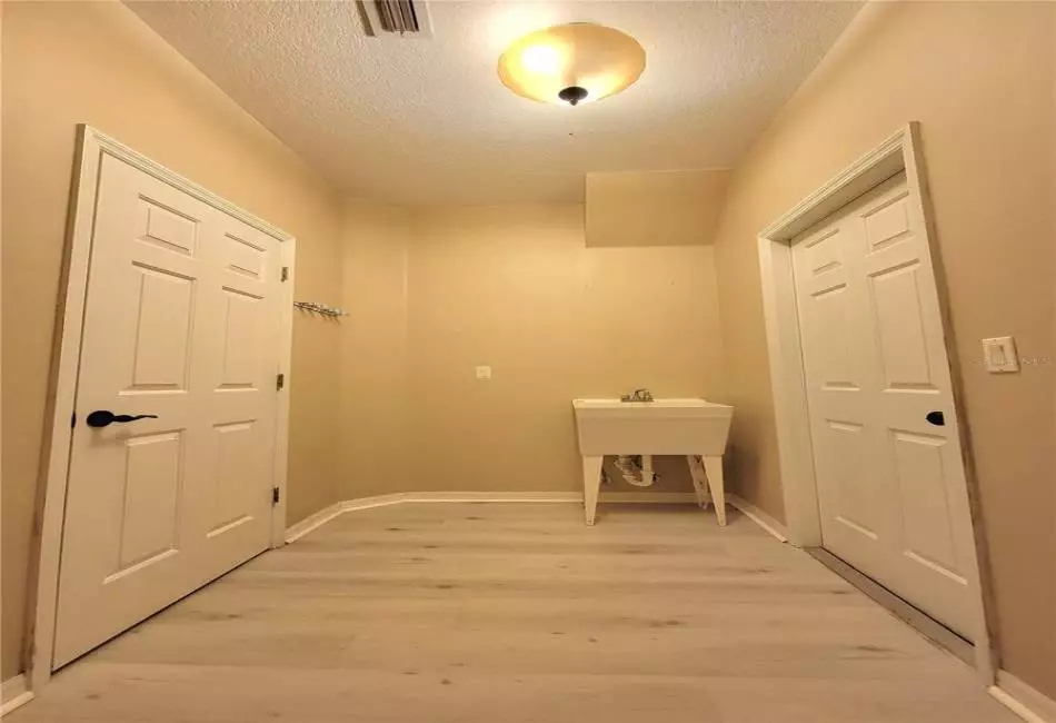 Separate Laundry Room with Laundry Sink and Luxury LVP Floors.
