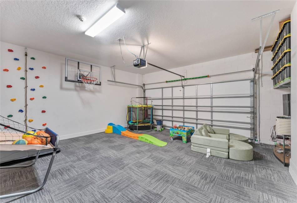 Converted garage with rock climbing wall and basketball hoop