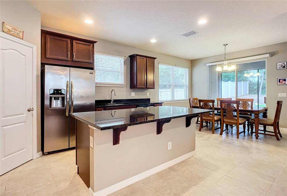 Open Concept Kitchen with Stainless Steel Applianced and Large Granite Island with Walk in Pantry