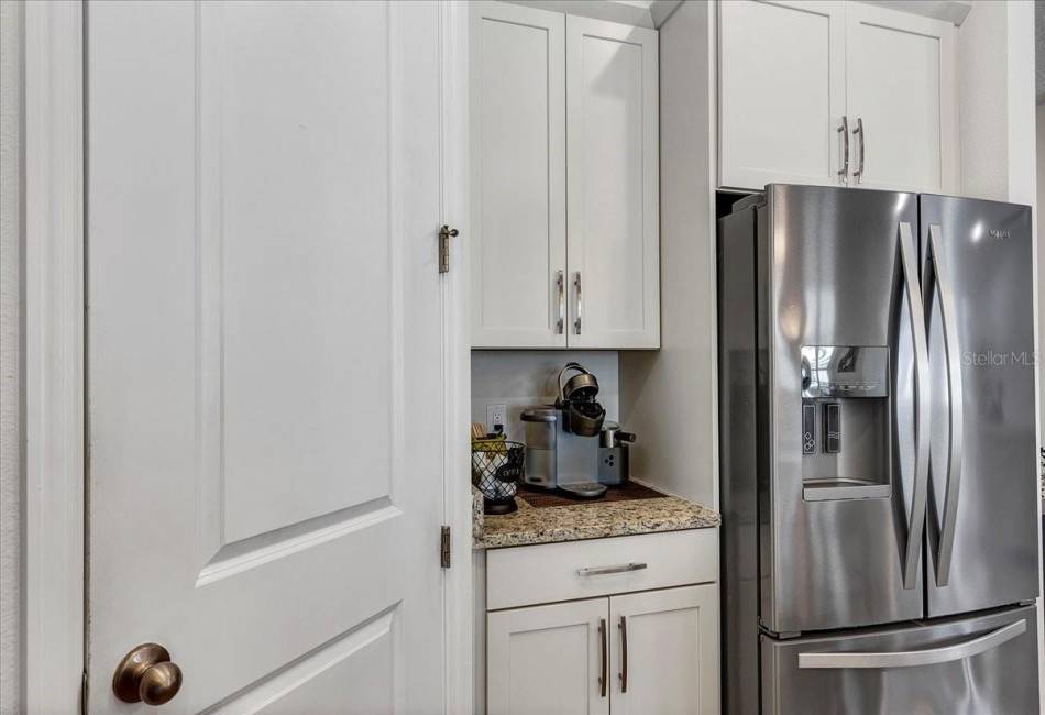Kitchen with pantry and stainless steel refrigerator