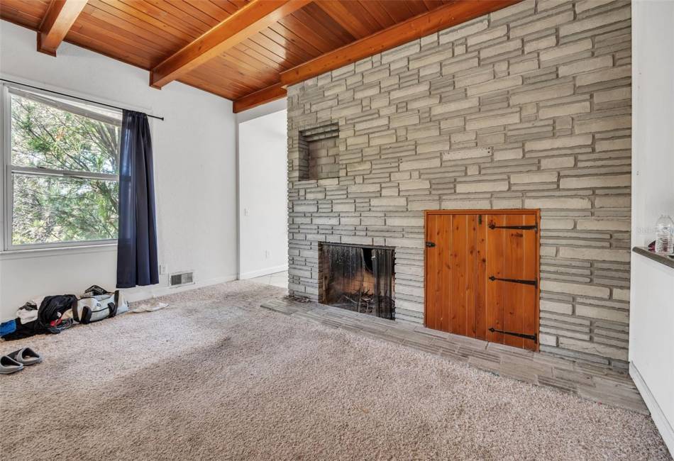 Living room with wood burning fireplace and wood storage