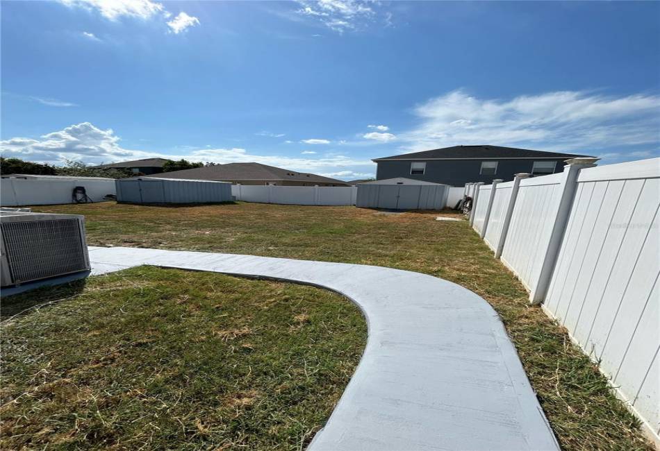 Private entrance to rear with sidewalk view of 2 sheds